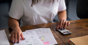 Profissional realizando cálculos sobre Base de Presunção do IRPJ e da CSLL na apuração tributária