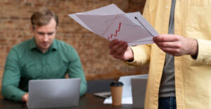 Profissional analisando gráficos sobre Importância do Envio Periódico de extratos bancários à contabilidade