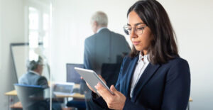 Profissional em ambiente corporativo consultando tablet sobre CBenef e Seus Impactos no cumprimento das obrigações acessórias